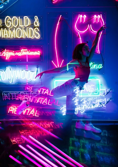 Kvinde danser med neonlys flow og bevægelse