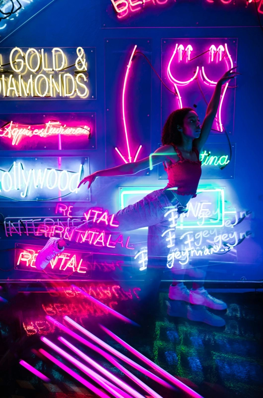 Kvinde danser med neonlys flow og bevægelse
