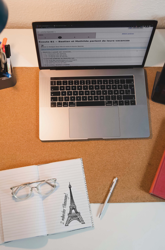 Computer på skrivebord med dansk/fransk ordbog